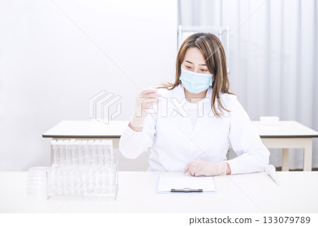Researcher conducting research, Researcher conducting an experiment, Woman holding a test tube, Image material 133079789
