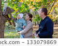 Happy family at the bird feeder. 133079869