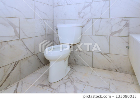 Modern white toilet in stylish marble bathroom with clean tiles spacious layout Modern white toilet in stylish marble bathroom with clean tiles spacious layout 133080015