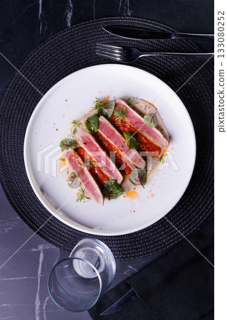 Seared Tuna Steak Slices on Creamy Sauce with Fresh Greens 133080252