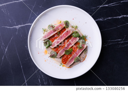 Seared Tuna Steak Slices on Creamy Sauce with Fresh Greens 133080256