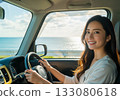 A woman smiling while driving along the seaside 133080618