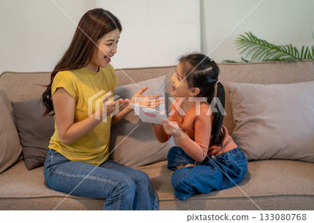 Lovely mom and little young daughter spending time together in their living room. 133080768