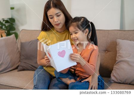 Lovely mom and little young daughter spending time together in their living room. 133080769