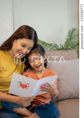 Lovely mom and little young daughter spending time together in their living room. 133080771