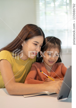 Lovely mom and little young daughter spending time together in their living room. 133080782