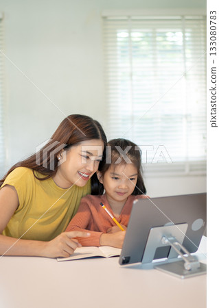 Lovely mom and little young daughter spending time together in their living room. 133080783