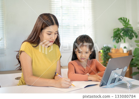 Lovely mom and little young daughter spending time together in their living room. 133080784