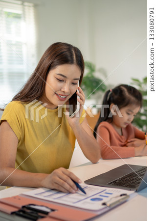 Lovely mom and little young daughter spending time together in their living room. 133080791