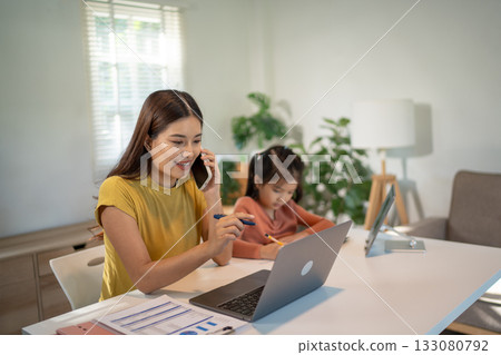 Lovely mom and little young daughter spending time together in their living room. 133080792