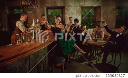 Elegant friends toasting in retro bar interior with lively vintage atmosphere Elegant friends toasting in retro bar interior with lively vintage atmosphere 133080827