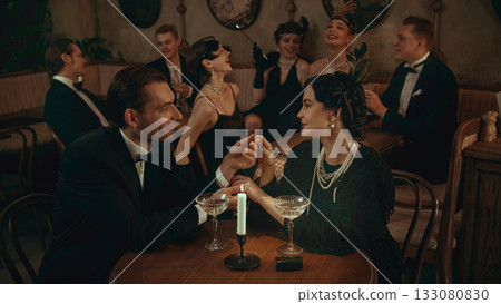 Elegant couple in vintage style sharing a romantic moment in warm candlelight 133080830