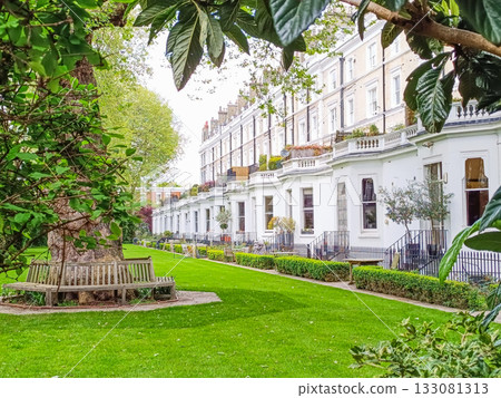 Elegant European courtyard garden with white townhouses and manicured lawn Elegant European courtyard garden with white townhouses and manicured lawn 133081313