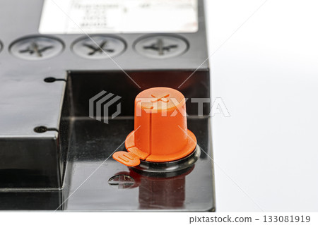 Car Battery Terminal with Bright Orange Safety Cap on Black Casing Car Battery Terminal with Bright Orange Safety Cap on Black Casing 133081919