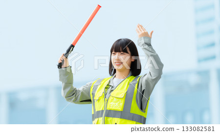 A young woman directing traffic at a construction site 133082581