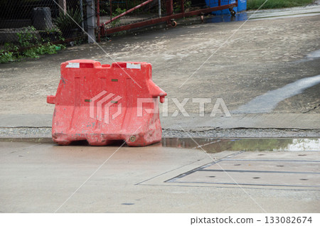 Red plastic barriers set up along the roadside Red plastic barriers set up along the roadside 133082674
