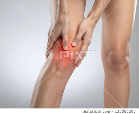 Woman holding painful knee with red inflammation highlight Woman holding painful knee with red inflammation highlight 133083203