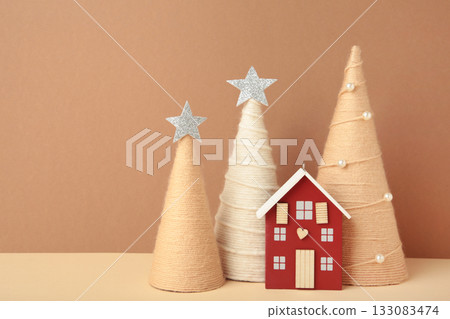 Happy New Year and Merry Christmas postcard. Wooden house with christmas tree on brown background. 133083474