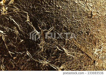 Gold foil's shimmering texture and intricate patterns in light 133083536