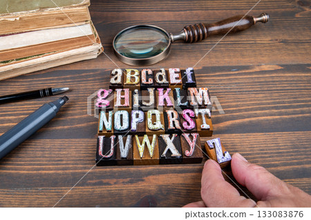 Complete alphabet made from colorful vintage wooden letterpress blocks with magnifying glass and old Complete alphabet made from colorful vintage wooden letterpress blocks with magnifying glass and old 133083876