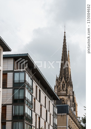 Modern architecture and a historic cathedral in Bayonne, France, under a cloudy sky. Modern architecture and a historic cathedral in Bayonne, France, under a cloudy sky. 133084682