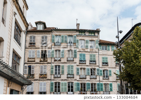 Charming white buildings with green shutters in the heart of Bayonne, France. Charming white buildings with green shutters in the heart of Bayonne, France. 133084684