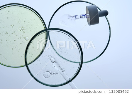 Three petri dishes with different serums and pipettes. Three petri dishes with different serums and pipettes. 133085462