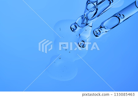 The texture of the facial serum on a blue background with pipettes. The texture of the facial serum on a blue background with pipettes. 133085463