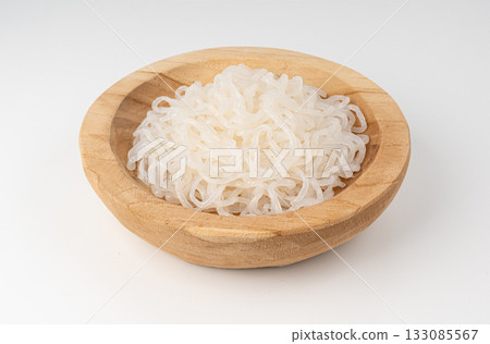 Shirataki or konnyaku pasta in wood bowl isolated. Konjak jelly noodles, Japanese zero calorie sirataki Shirataki or konnyaku pasta in wood bowl isolated. Konjak jelly noodles, Japanese zero calorie sirataki 133085567