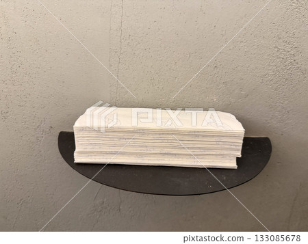 Stack of paper napkins on metal shelf. Cleanliness, organization, and minimalism in functional interior design. Stack of paper napkins on metal shelf. Cleanliness, organization, and minimalism in functional interior design. 133085678