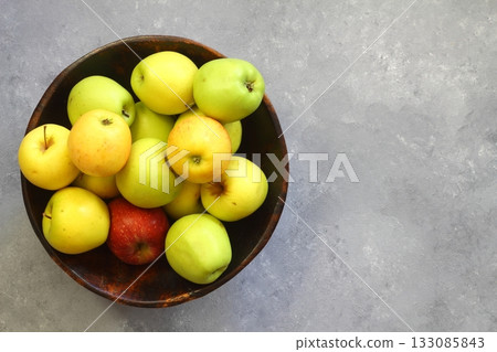 Fresh organic ripe apples in a bowl on a grey background, top view. Copy space 133085843