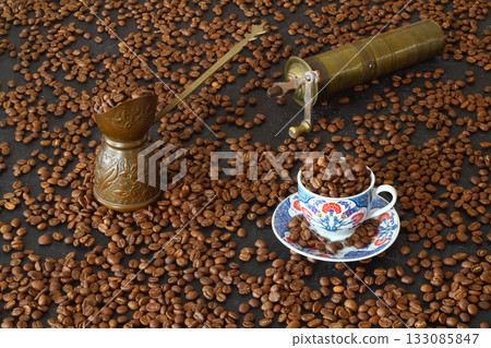 Turkish coffee concept. Copper pot (Cezve), vintage coffee grinder, coffee beans on a dark wooden background. 133085847