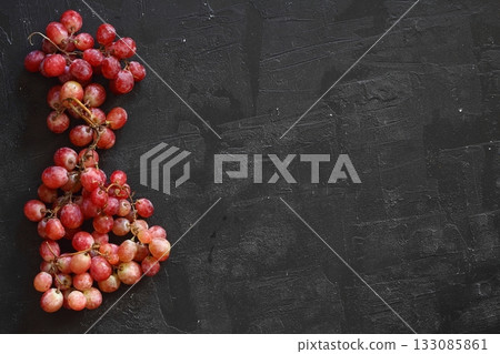 Bunch of fresh ripe juicy red grape flat lay on white background, copy space for text Bunch of fresh ripe juicy red grape flat lay on white background, copy space for text 133085861