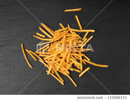Fried chips sticks, finger potato chips, golden shoestring fries pile, French fries 133086331