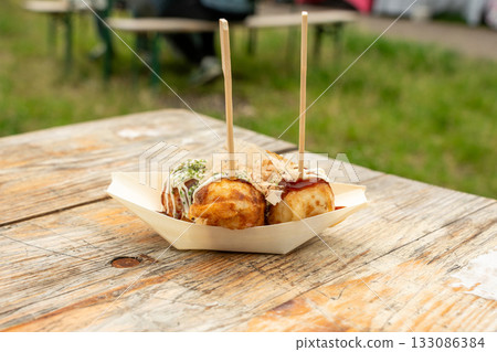 Takoyaki - traditional Japanese street food, outdoor snack with octopus Takoyaki fried balls 133086384
