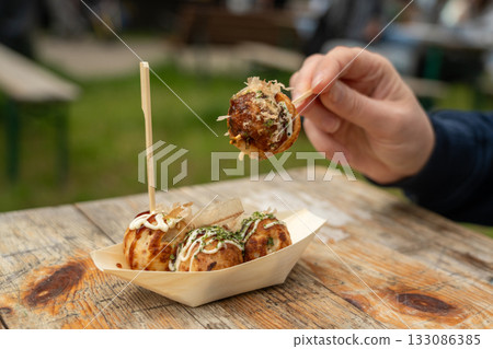 Takoyaki - traditional Japanese street food, outdoor snack with octopus Takoyaki fried balls Takoyaki - traditional Japanese street food, outdoor snack with octopus Takoyaki fried balls 133086385