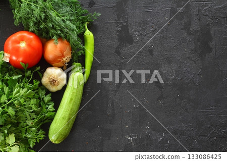 Food cooking background on black stone table. Fresh vegetables, herbs. Ingredients for cooking. Top view with copy space. Food cooking background on black stone table. Fresh vegetables, herbs. Ingredients for cooking. Top view with copy space. 133086425