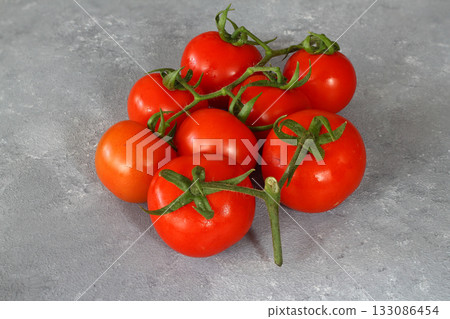 Fresh cherry tomatoes on a black background. Bunch of fresh cherry tomato on a black background 133086454