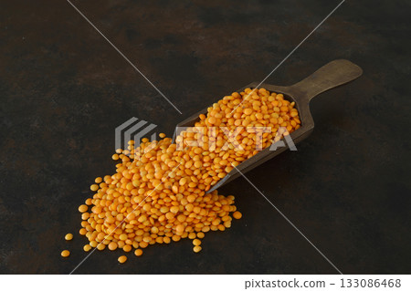 Heap of red lentil with wooden spoon. Healthy eating containing natural vitamins and minerals. Heap of red lentil with wooden spoon. Healthy eating containing natural vitamins and minerals. 133086468