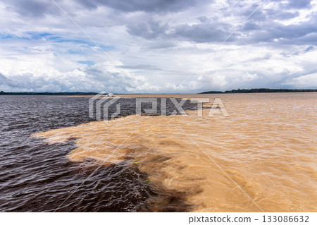 Meeting of the waters of the Negro and Solimoes rivers in the city of Manaus in Amazonia, Brazil 133086632