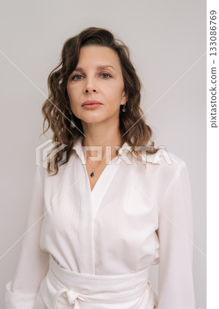 Vertical portrait of serious female cosmetologist looking at camera, portraying expertise, confidence, and experience in beauty, medical aesthetics, and skin care services. Concept of beauty treatment Vertical portrait of serious female cosmetologist looking at camera, portraying expertise, confidence, and experience in beauty, medical aesthetics, and skin care services. Concept of beauty treatment 133086769