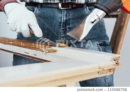 Carpenter at work, restoring an old wooden window. Carpentry. Carpenter at work, restoring an old wooden window. Carpentry. 133086798