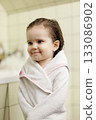 Cute toddler wrapped in towel in tiled bathroom 133086902