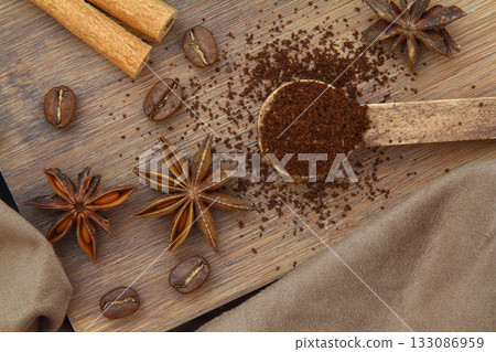 Coffee beans, cinnamon sticks, anise and wooden spoon close-up 133086959