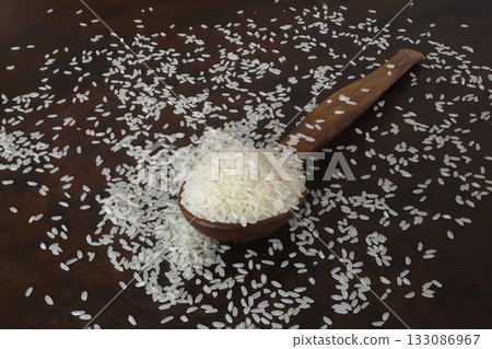 raw white rice on dark rustic wooden background raw white rice on dark rustic wooden background 133086967