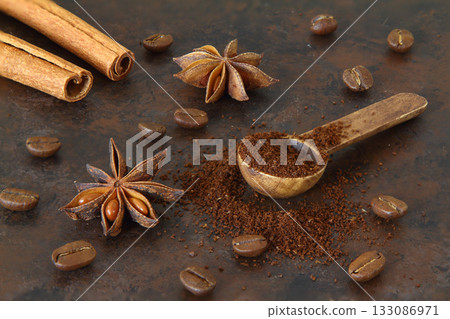 Coffee beans, cinnamon sticks, anise and wooden spoon close-up Coffee beans, cinnamon sticks, anise and wooden spoon close-up 133086971