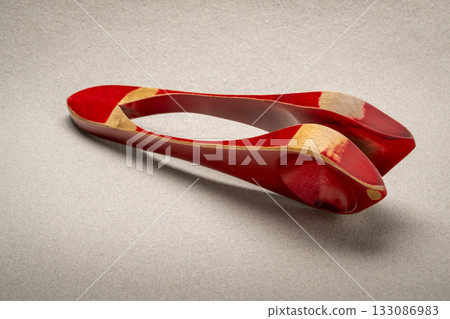 Wooden musical spoons, folk percussion instrument on textured paper 133086983