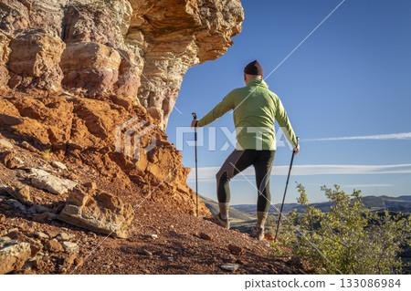 senior hike hiker in his 70s with trekking poles enjoying scenic views in Red Mountain Open Space in northern Colorado 133086984