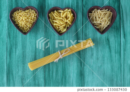 Italian Food background on green table Top view. With heart shaped bowl Italian Food background on green table Top view. With heart shaped bowl 133087430