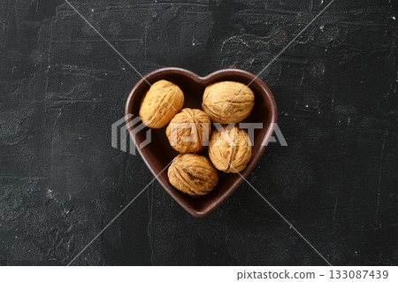 Inshell walnuts in a heart-shaped plate. Heart Nuts, Heart Health Products, Structured Walnuts Healthy food protein Inshell walnuts in a heart-shaped plate. Heart Nuts, Heart Health Products, Structured Walnuts Healthy food protein 133087439
